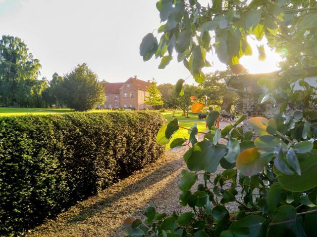 De zon geeft de tuin van kasteel Boller bij Horsens een gouden gloed.