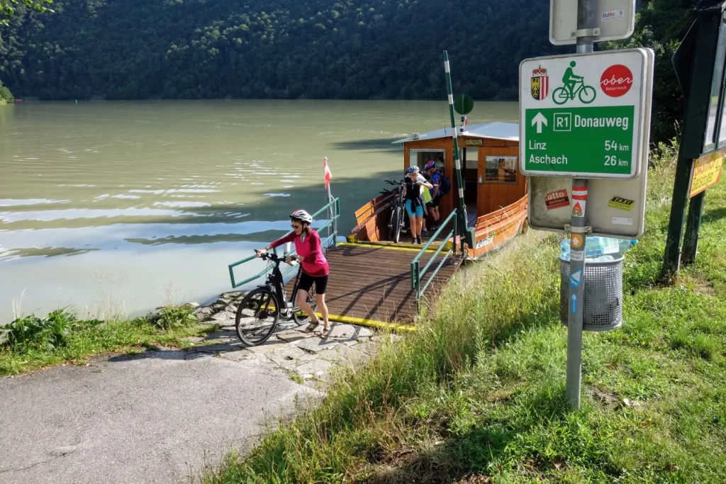 Fietsers steken met een pontje de Donau over