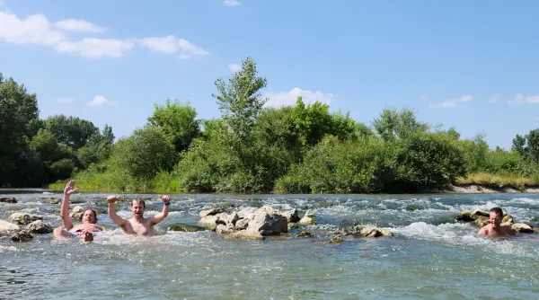 Drie mensen liggen in de stroming van de Drava-rivier