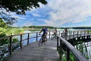 Drie fietsers rijdend over de vlonderbrug in Mazurië