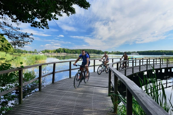 Drie fietsers rijdend over de vlonderbrug in Mazurië
