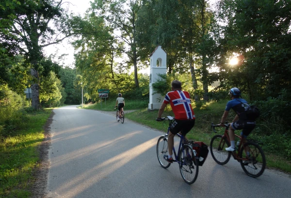 Drie fietsers passeren een dorpje in Warmië, niet ver van Frombork